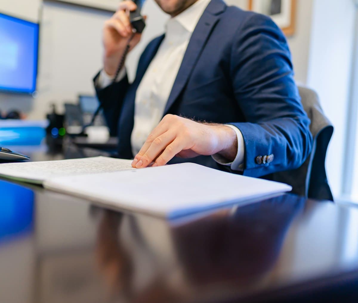 Man sitting at a desk writing on paper while planning a work schedule