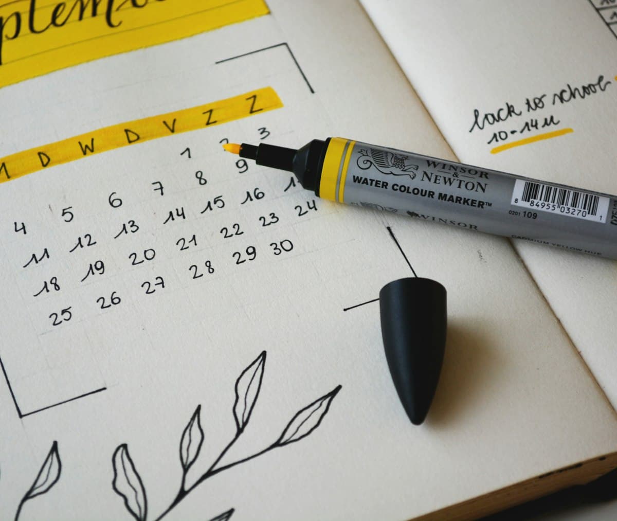 Black marker resting on a notebook, ready to note down dates and deadlines
