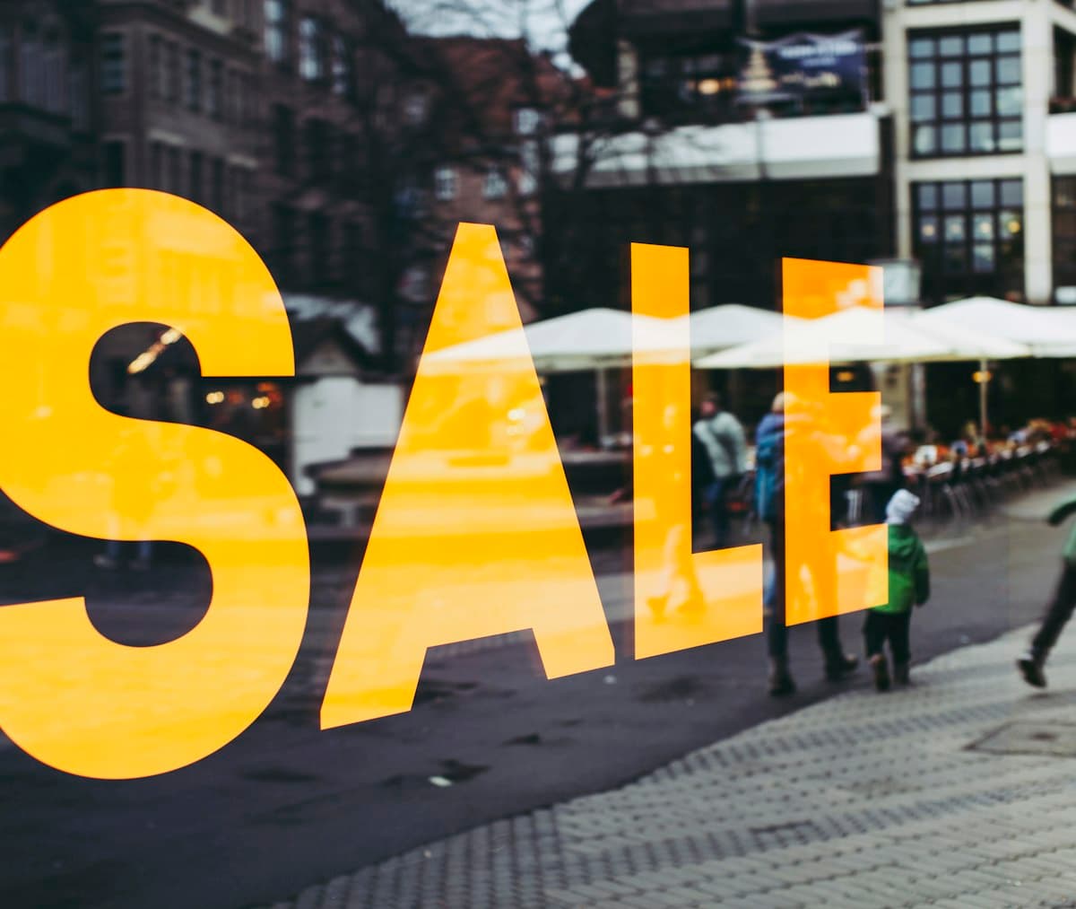 Yellow SALE sign on a shop window overlooking a pedestrian street in Nürnberg