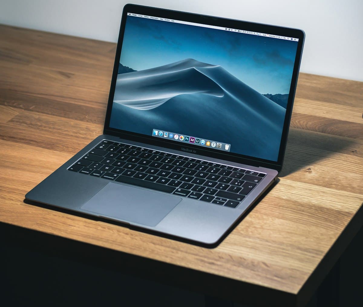 Open laptop on a wooden desk in a freelancer's home office
