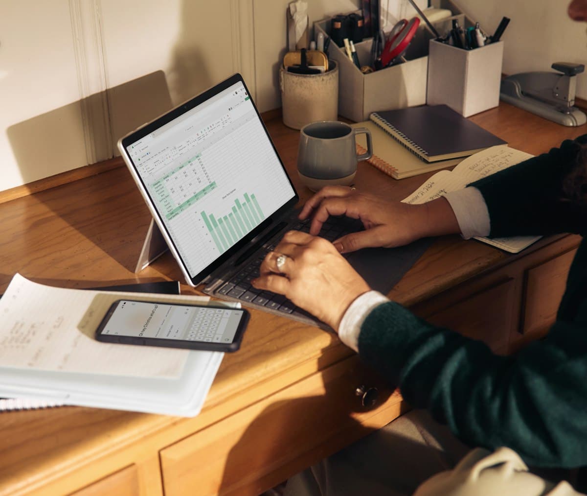 Person working on a laptop at a wooden desk, earning an hourly wage