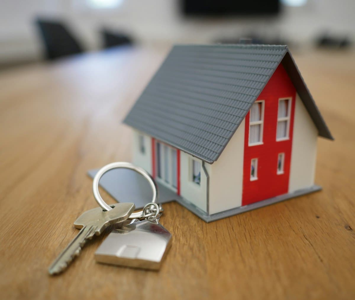 Miniature white and red wooden house on a brown table, representing a home loan