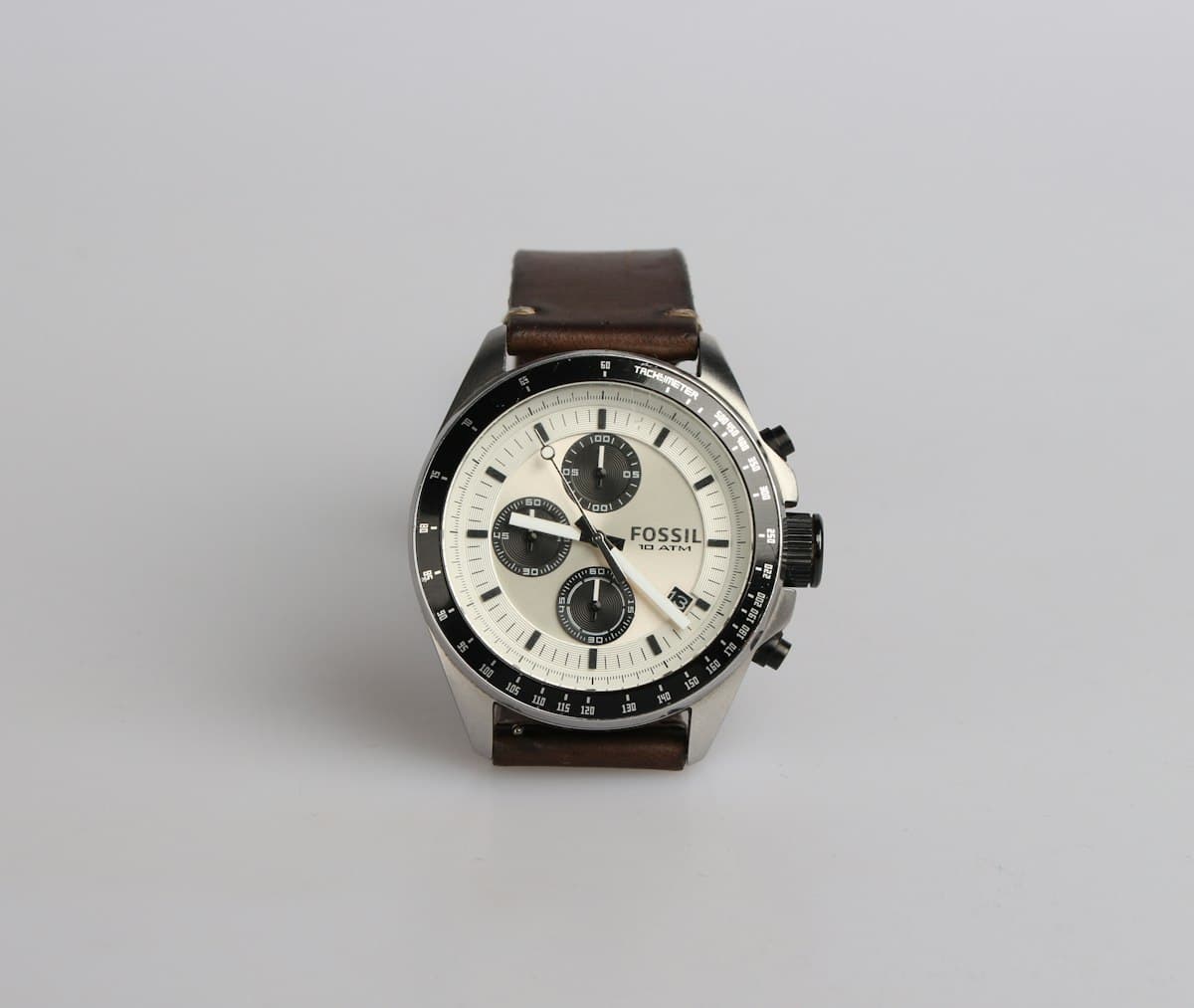 Silver chronograph watch with a brown leather band showing 9:22, tracking overtime hours