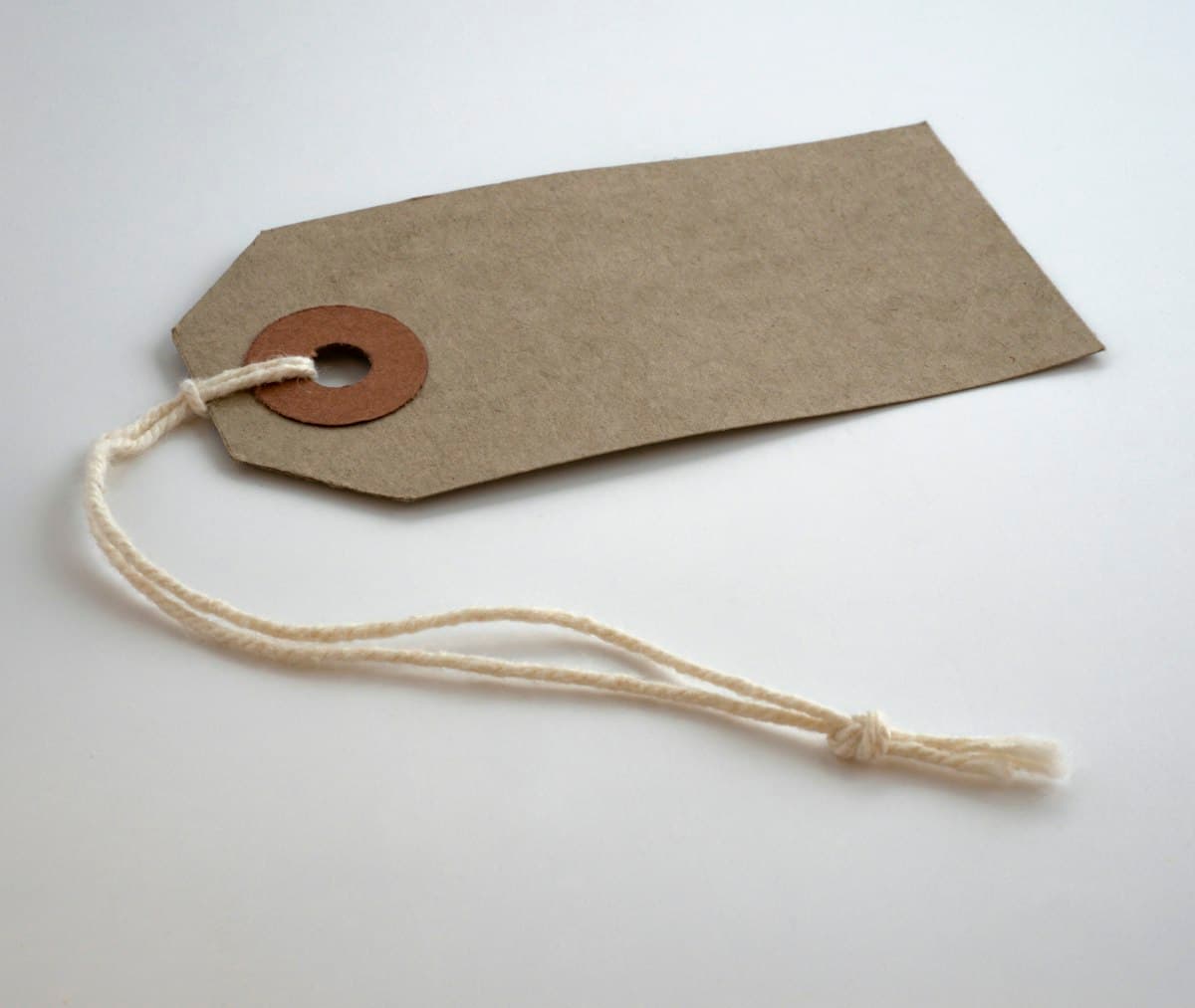 Gray paper price tag lying on a surface, showing a price after a percentage change