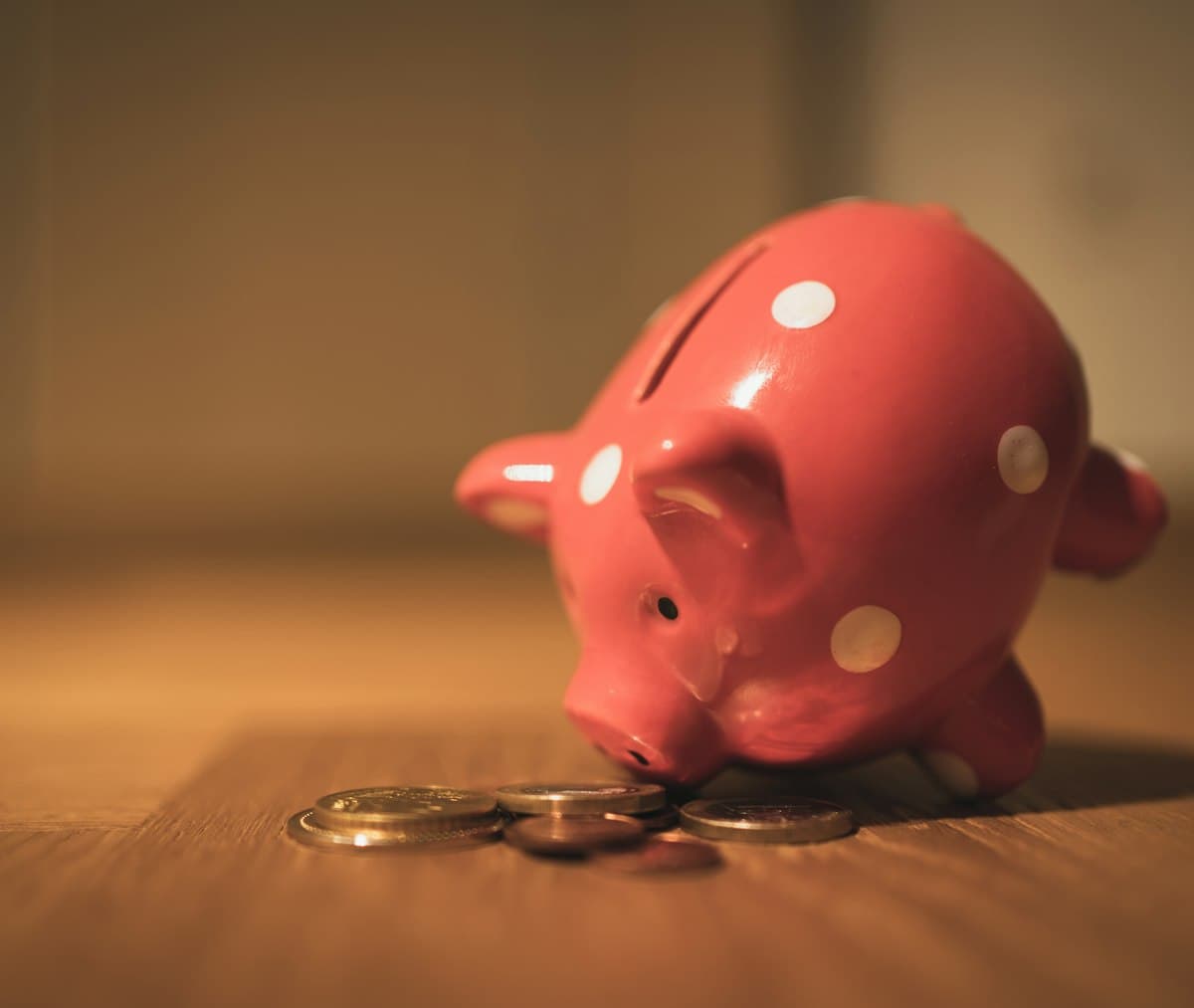 Pink piggy bank on a brown wooden table, a classic symbol of saving money