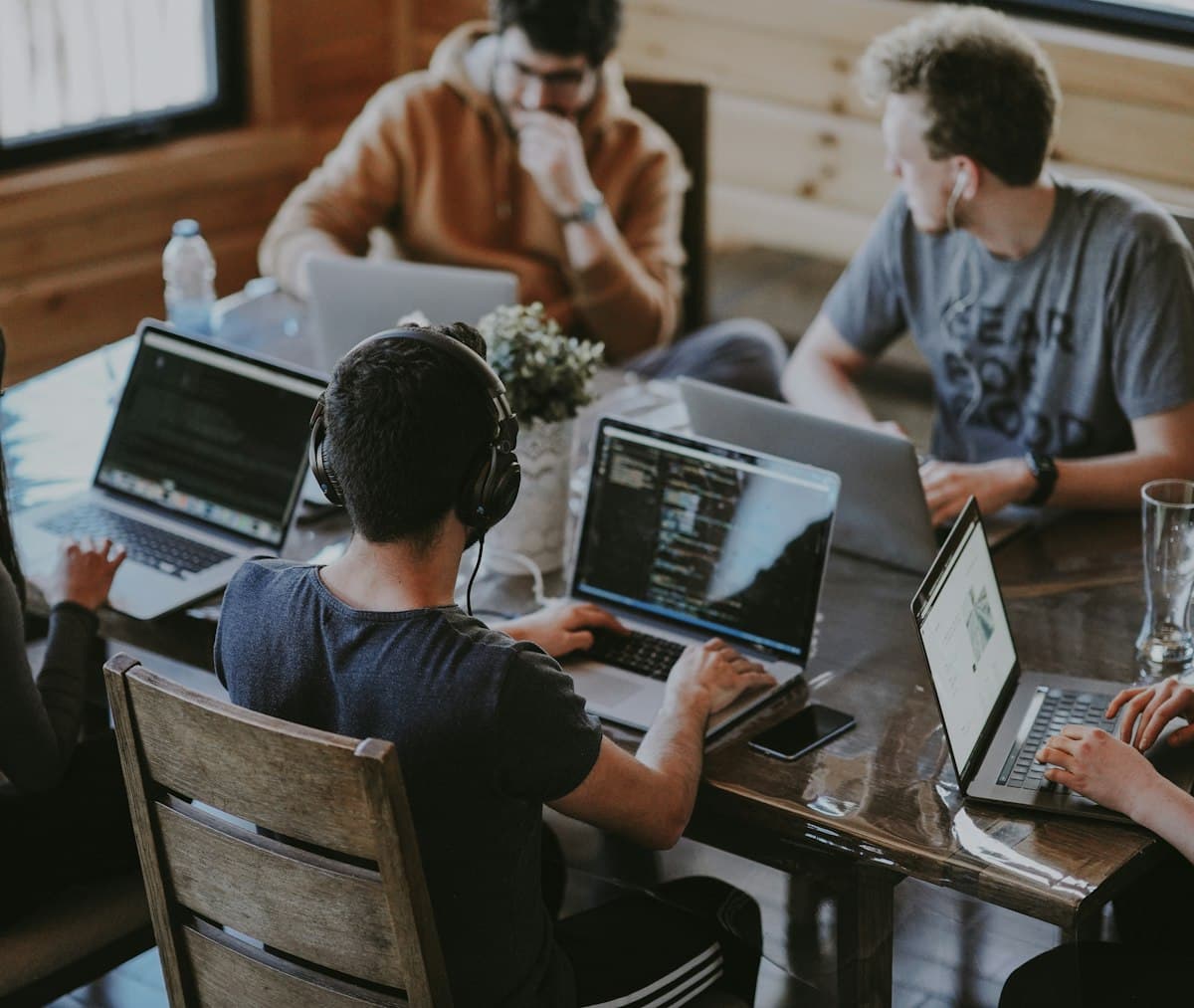 Group of students using laptops together while studying for exams and tracking their grades